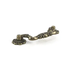 Detail shot of vintage bronze cabinet pull handle with classic embossed floral pattern.