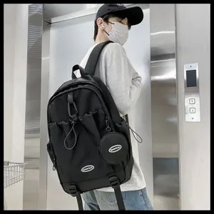 Grand sac à dos noir avec cordon et pochette pour étudiant dans un cadre urbain moderne.