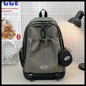 Vue détaillée d'un sac à dos de sport vert avec poche avant à cordon et petite pochette ronde.