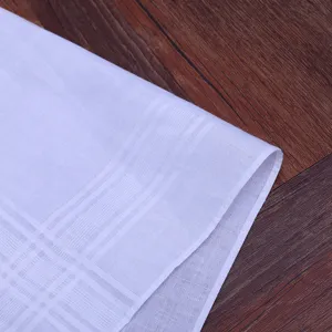 Pure white cotton handkerchief detail shot, soft fabric texture with elegant woven striped border.