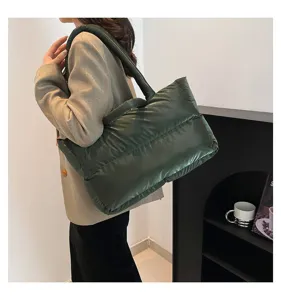Detailed view of the dark green quilted space cotton tote bag worn on shoulder