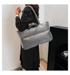 Large silver space cotton puffer shoulder bag shown on model in a modern interior