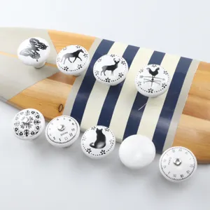 Various ceramic drawer knobs featuring black animal and clock patterns for kid's furniture