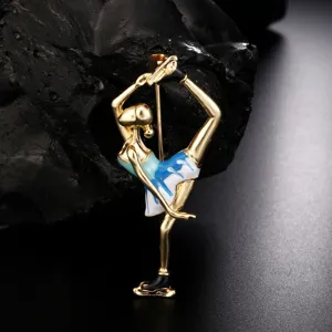 Macro detail of a golden enamel ballet dancer brooch with elegant blue and white patterns