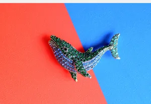 Detailed view of a green and blue rhinestone whale brooch for fashion accessories.