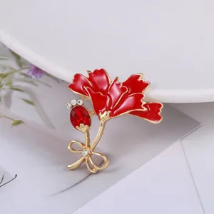 Close-up of red enamel carnation flower brooch with crystal and rhinestone details
