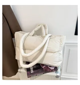 Macro view of white space cotton puffer tote bag featuring soft quilted texture details