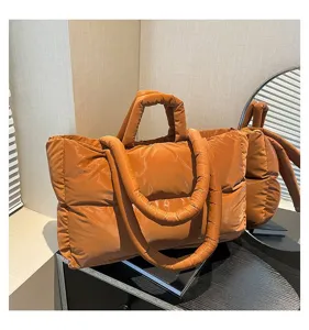 Stylish orange puffer tote bag made of quilted space cotton for winter fashion