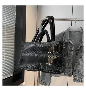 Premium glossy black quilted padded space cotton tote bag hanging on a metal rack.