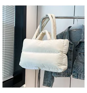 Minimalist white puffy space cotton shoulder bag shown on a clothing rack display