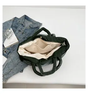 Detailed interior view of dark green quilted puffer tote bag with beige lining