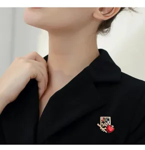 Detailed view of teacher appreciation apple brooch with ABC 123 design on black blazer.