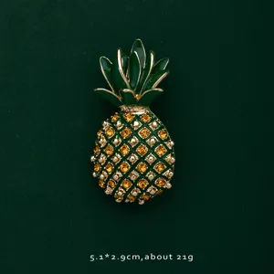 Macro view showing details of a pineapple brooch with yellow crystals and green enamel