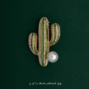 Detailed view of elegant cactus brooch with sparkling rhinestones and a large pearl