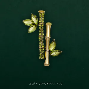 Close-up of bamboo lapel pin with green crystal leaves and gold-tone stems