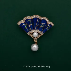 Detailed view of fan-shaped blue enamel brooch with bamboo pattern and pearls