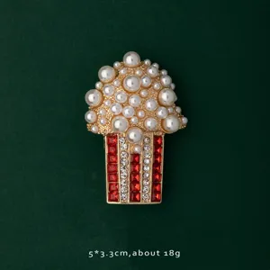 Close-up detail of a vintage popcorn brooch pin featuring pearls and red rhinestones.