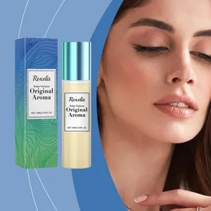 Κοντινό πλάνο αρώματος Roxelis roller και της συσκευασίας δίπλα στο πρόσωπο ενός μοντέλου