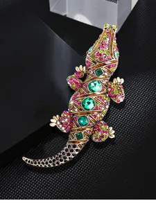 Detailopname van een levendige krokodillenbroche met strass-steentjes en groene edelstenen.