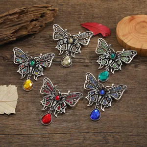 Detailed view of five vintage hollow butterfly brooches with colorful teardrop crystal pendants