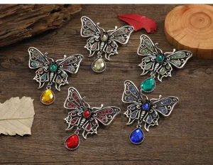 Macro view of five vintage butterfly brooches with colorful rhinestones and teardrop pendants
