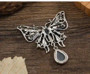 Detailed macro view of the vintage hollowed butterfly brooch back pin mechanism.