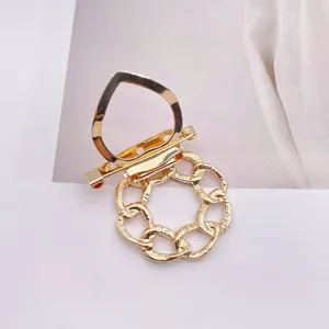 Detailansicht der goldenen Metall-Brosche und des Schal-Clips mit Doppel-Funktion.