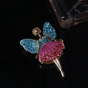 Detailed close-up of a ballet girl brooch with blue and pink rhinestones on black