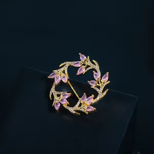 Elegant gold-tone wreath brooch featuring pink marquise stones and micro-pave crystals