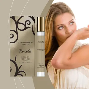 Elegant woman smelling her wrist next to a 10ml sandalwood amber roll-on perfume set.