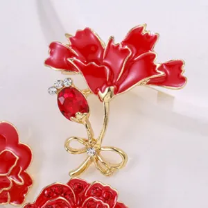 Close-up of red enamel flower brooch with rhinestones and gold-tone finish