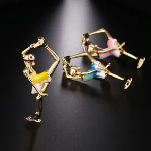 Detailed macro view of an elegant gold-plated enamel ballet dancer fashion brooch pin.
