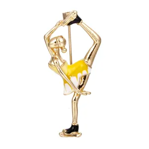 Elegant enamel ballet dancer brooch in gold-toned metal with yellow and white dress