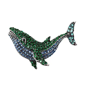 Elegant whale brooch pin with sparkling green and blue crystals for denim jackets