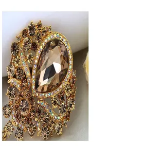 Detailed macro view of a luxury champagne crystal brooch with pear-shaped pendant