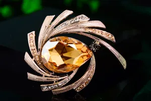 Close-up detail of elegant amber crystal brooch with radiant rhinestone star petals