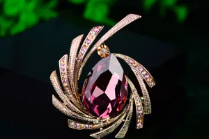 Close-up of elegant purple pear-shaped crystal brooch with sparkling rhinestone details