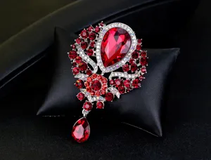 Macro detail view of a luxury vintage brooch featuring radiant red glass crystals