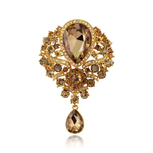 Luxurious vintage gold-tone alloy brooch featuring champagne crystals and a teardrop pendant