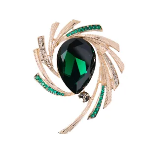 Elegant starburst brooch with green teardrop crystal and sparkling rhinestones
