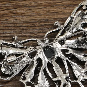 Detailed back view of a vintage hollow butterfly brooch showing the secure pin closure