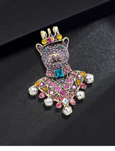 Dettaglio di una spilla a forma di orso in stile vintage con strass colorati e perle.