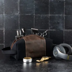 Detail view of a men's vintage canvas and leather dopp kit with grooming accessories
