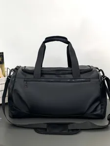 Vue détaillée du sac de voyage noir montrant des fermetures éclair robustes et des poignées.