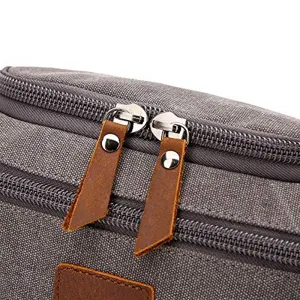Detail of durable gray canvas toiletry bag with premium dual leather zipper pulls