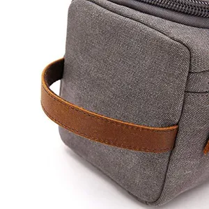 Macro view of durable grey canvas fabric and sturdy brown leather handle on a travel bag