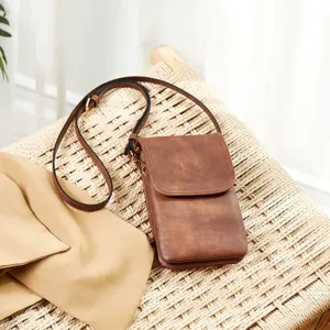 Detailed close-up of a vintage brown PU leather crossbody phone bag on a woven chair