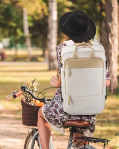 Gedetailleerde lifestyle-foto van een grote witte rugzak voor dames op een fiets in het park