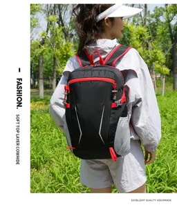 Detailed view of outdoor black backpack with red accents and mesh pockets worn outdoors.