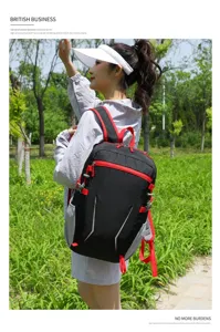 Detail view of lightweight black and red backpack worn by model outdoors, multi-pocket design